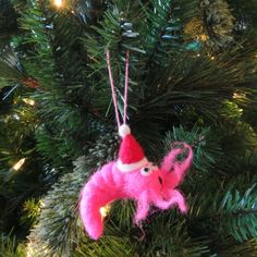 a pink ornament hanging from a christmas tree