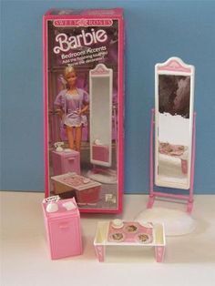 a barbie doll is standing in front of a mirror and table with a toy bed