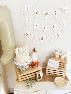 a table topped with a cake and lots of other items next to a balloon in the shape of a chicken