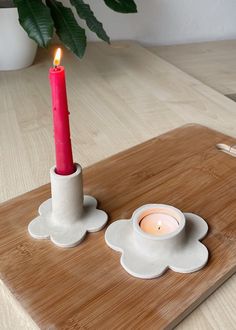 a lit candle sitting on top of a wooden tray