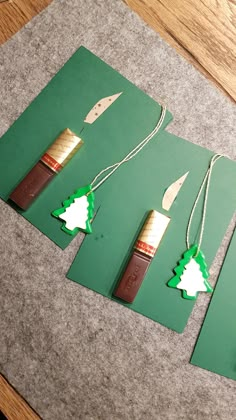 three pieces of green paper with some brown and white items on them sitting on a table