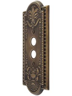 an ornately decorated metal door handle with two holes in the middle and one hole on the side