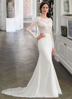 a woman in a white wedding dress posing for the camera with her hands on her hips