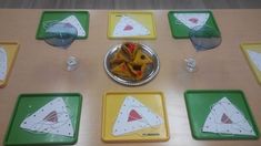 a table topped with lots of different colored plates and trays filled with food on top of it