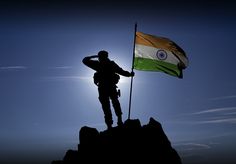 a man standing on top of a mountain holding a flag