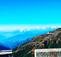 a view from the top of a mountain with mountains in the background