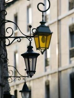 two street lights hanging from the side of a building