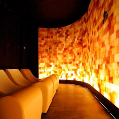 a row of yellow chairs sitting in front of a wall with orange squares on it