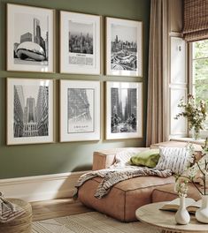 a living room with green walls and pictures on the wall above the couch, along with vases filled with flowers