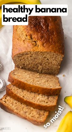 a loaf of healthy banana bread sitting on top of a white plate next to some bananas