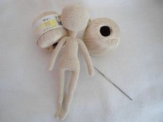 the doll is made out of yarn and has a needle in it's mouth