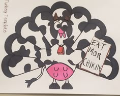 a paper cut out of a cow holding a sign