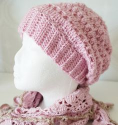 a crocheted pink hat and scarf on a mannequin's head