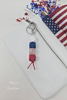 an american flag is on the back of a white purse with a keychain