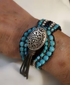 I design and create all the jewelry in my collection and find inspiration in the work of Native American artisans.  This beautiful handcrafted cuff bracelet may be custom created to accommodate any size wrist. It boasts rows of turquoise colored Howlite, black jasper and silvertone beads entwined with six  strands of deep slate leather cord. The ornate silvertone toggle closure is encircled by graduated Howlite beads. This bracelet measures 1-1/8" in width and 7-1/2" in length. P.S. I love this Artisan Turquoise Hand Wrapped Wrap Bracelet, Artisan Hand Wrapped Turquoise Wrap Bracelet, Handmade Turquoise Wrap Bracelet, Handmade Southwestern Turquoise Cuff Bracelet, Bohemian Turquoise Nickel-free Cuff Bracelet, Adjustable Southwestern Turquoise Cuff Bracelet, Adjustable Turquoise Southwestern Cuff Bracelet, Black Beaded Bohemian Cuff Bracelet, Black Bohemian Cuff Bracelet With Round Beads