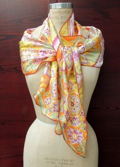 "Vintage \"Sunshine\" Scarf. Perfect for Festival Fashions. This lovely retro headscarf is printed on medium weight fabric, Most likely polyester? It has some \"body\" to it probably because of the fabric content and it is printed with an overlay of gold lurex outlining certain areas of the design. It is printed in a very usable pallet of oranges, yellows, greens and purple, on a off-white ground. It has a stylized floral design, with striped diagonal elements in the background and with a machine over-locked hem, that lettuces in areas of the curve- makes for wonderful styling configurations and makes a great cover up! Sash style, retro scarf is a generous (approx) 76 x 16 inches, at it's widest point, it is an interesting overall shape, with an undulating hem line- see photos.   This scar Yellow Bohemian Bandana For Summer, Vintage Silk Scarf For Summer Gift, Vintage Silk Scarf Summer Gift, Multicolor One-size Headscarf As Gift, Multicolor One Size Headscarf For Gift, Yellow Summer Bandana, Vintage Scarves For Summer Festivals, Vintage Summer Scarves For Festivals, Vintage Summer Festival Scarves