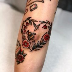 a woman's arm with tattoos and flowers on it