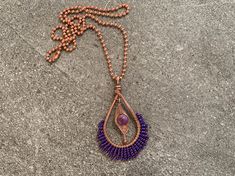 This starburst necklace features a stunning, handcrafted copper pendant framing a wirewrapped dangling stone with intricate beaded details. A hammered teardrop pendant perfectly frames the purple agate bead at its center, and ends in a burst pattern of wire wrapped Japanese seed beads in eye-catching iridescent purple. The pendant hangs gracefully from a 20-inch copper ball chain, adding a rustic yet refined touch to this one-of-a-kind piece. Whether you're dressing up for a special occasion or adding a stylish flair to your everyday look, this pendant is sure to become a favorite in your jewelry collection. Flaunt this rustic boho look with a modern mystical feel to compliment your style and elevate any outfit. Part of the beaded burst collection, the design was inspired by the ever-prese Wire Wrapped Copper Wire Teardrop Pendant Necklace, Handmade Purple Copper Wire Necklace, Handmade Purple Necklace With Copper Wire, Hand Wrapped Purple Copper Necklace, Purple Wire Wrapped Copper Wire Necklace, Mystic Jewelry, Starburst Necklace, Iridescent Purple, Mystical Jewelry