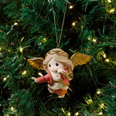 an angel ornament hanging from a christmas tree