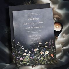 the wedding card is surrounded by flowers and candles