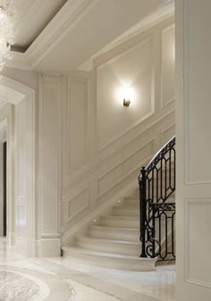 an elegant staircase with chandelier and marble flooring in a large white building