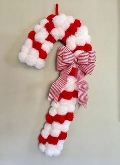 a red and white striped christmas wreath hanging on a wall