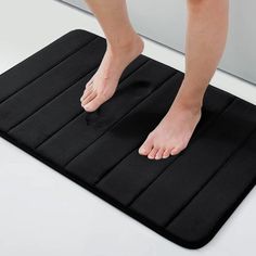 a person standing on top of a black mat