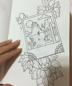 a person is holding up a drawing with flowers and cactuses in the frame on paper