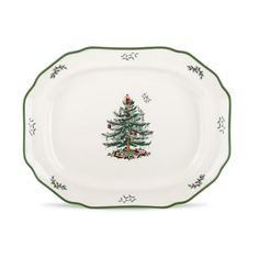 a white plate with a green trimming and a christmas tree on the side,