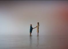 two people standing in the fog holding hands