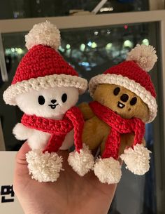 two teddy bears wearing hats and scarves are held in front of a mirror with lights behind them