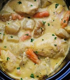 chicken, potatoes and carrots stew in a crock pot on a wooden table