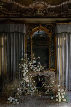 an ornate room with flowers on the floor and a mirror in the wall behind it