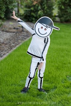 a person in a costume is standing on the grass and holding his arms out with both hands