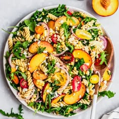 a bowl filled with pasta salad next to sliced peaches