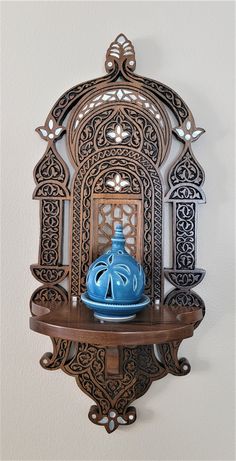 a blue vase sitting on top of a wooden shelf