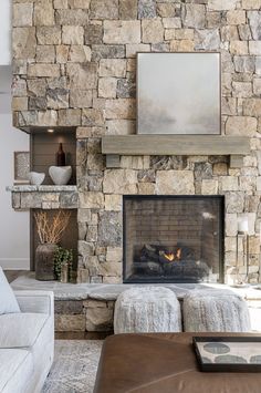 a living room with a stone fireplace and two couches