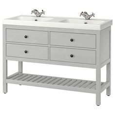 the double sink vanity has two faucets on each side and is painted white