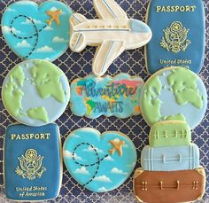 decorated cookies in the shape of an airplane, luggage and map on a blue background