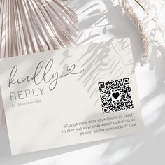 a white business card sitting on top of a table next to some palm fronds