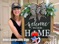 a woman holding up a welcome to our home sign