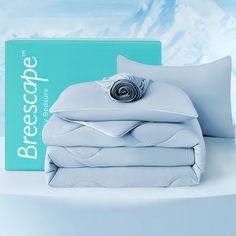 a stack of white sheets and pillows on top of a bed