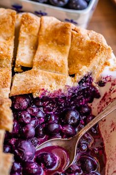 blueberry cobbler in a bowl with a serving spoon