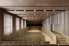 an empty auditorium with wooden walls and stairs