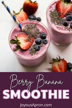 berry banana smoothie with strawberries and blueberries in it on a white surface