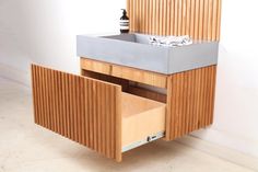 a wooden sink cabinet with two drawers and a soap dispenser next to it