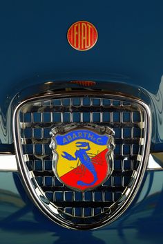 an emblem on the front of a blue car with red, yellow and blue stripes