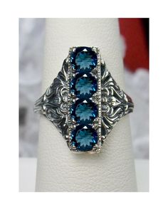 Natural London Blue Topaz Ring  4 Gem Design#72 Custom Order This is a lovely late Victorian, early Edwardian, era reproduction ring in antiqued sterling silver (White gold plated). The gorgeous filigree ring is set with 4 round cut Lonodn Blue Topaz gemstones. The London Topaz gemstones are 4mm in diameter. This filigree setting is a revival of an authentic Antique ring; notice the amazing etched band... The ring sits 3/4th" (19mm) North to South on the finger. The quality the ring is simply br Victorian Blue Topaz Ring, Vintage Sapphire Jewelry With Accent Stones, Vintage Blue Topaz Ring With Intricate Design, Victorian Blue Topaz Ring For Anniversary, Vintage Blue Topaz Birthstone Jewelry, Antique Blue Topaz Ring, Victorian Sterling Silver Topaz Ring, Vintage Sterling Silver Topaz Ring With Filigree, Vintage Sterling Silver Topaz Ring With Intricate Design