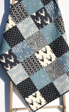 a black and white quilt sitting on top of a wooden chair