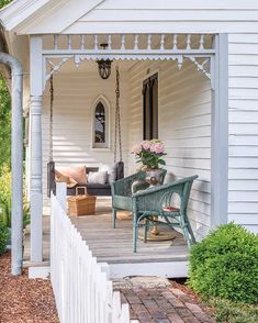 a porch with a swing and chairs on it